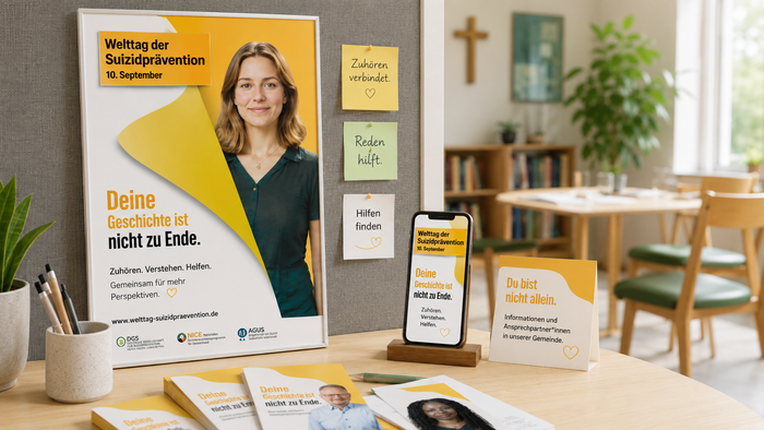 Ein Schreibtisch mit Material zum Welttag der Suizidprävention am 10. September: Plakat, Flyer und Smartphone tragen Botschaften wie „Deine Geschichte ist nicht zu Ende“, „Zuhören verbindet“ und „Reden hilft“.
