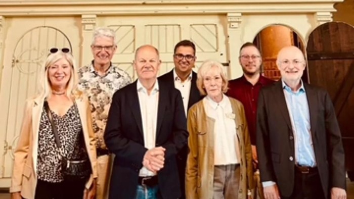 Eine Gruppe posiert vor einer großen Orgel in der St.-Jakobi-Kirche in Luckenwalde, mit Olaf Scholz.