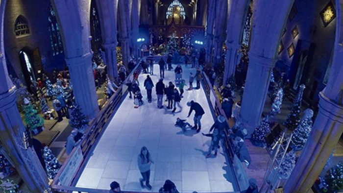 Large indoor market with people walking and shopping.