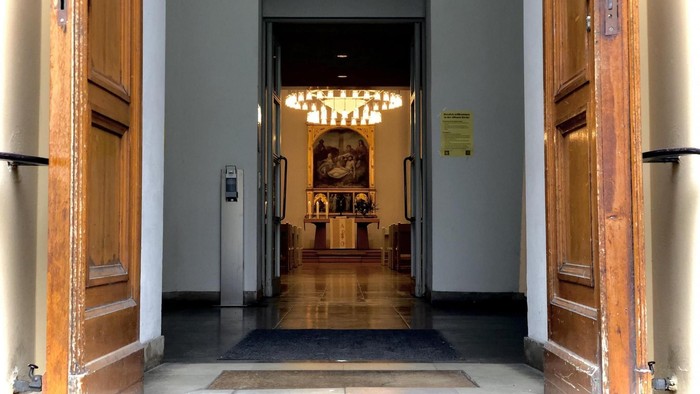 Offene Eingangstür der Luisenkirche, im Innenraum sind ganz hinten der Altar zu sehen.