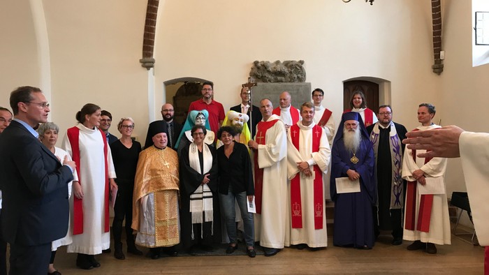 Eine Gruppe von Menschen in religiöser Kleidung steht in einer Kirche.