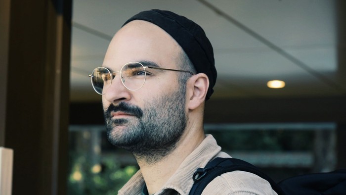 Bild von Pfarrer Eike Thies im Profil: helle Cord-Jacke, dunkler Dreitagebart, runde Brille, schwarze Mütze.
