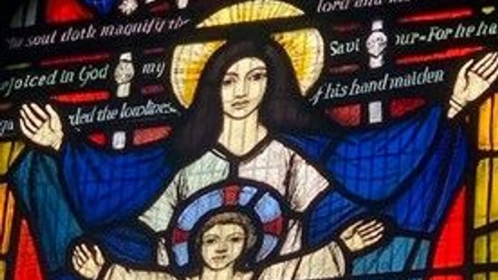 Stained glass window depicting a religious scene with a woman and child.