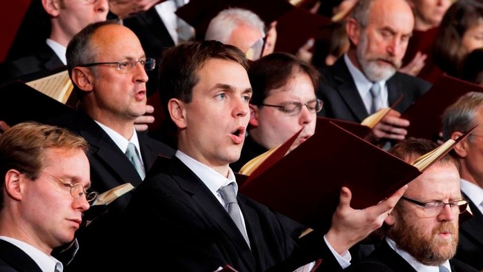 Ein Männerchor singt aus Notenbüchern