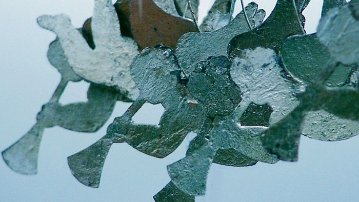Gläserne Vögel hängen an rotem Draht