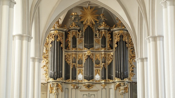 Prachtvolles Kircheninnere mit verziertem Orgelpult und hohen Bögen