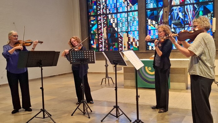 Vier Violinistinnen spielen in einem modernen Altarraum