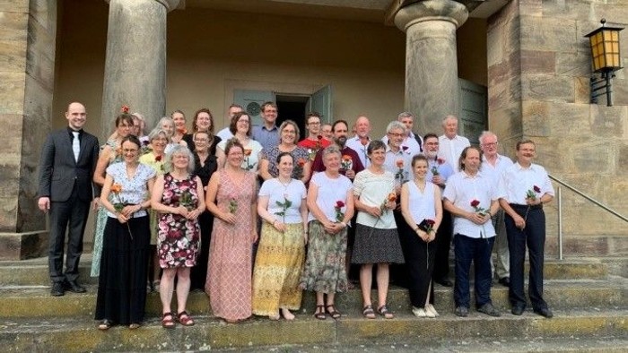 Gruppenbild des Projektchores und den Mitgliedern des Posaunenchores vor der Kirche in Gräfinau-Angstedt.