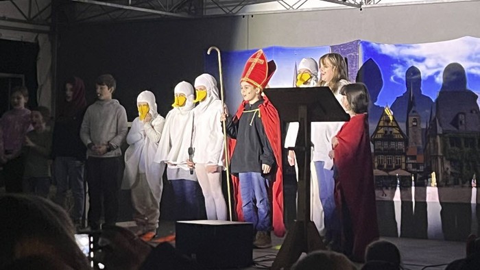 Eine Theatergruppe führt ein Stück auf einer Bühne auf.