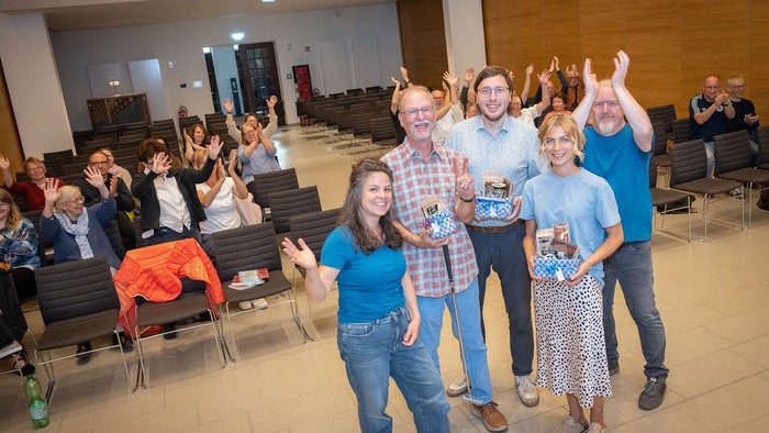 Gruppe jubelt und hebt die Hände bei einer festlichen Indoor-Veranstaltung mit Auszeichnungen.