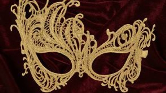 Elegante Goldspitzenmaske mit aufwendigen floralen und Rankenmustern, platziert auf einem tiefroten Hintergrund.