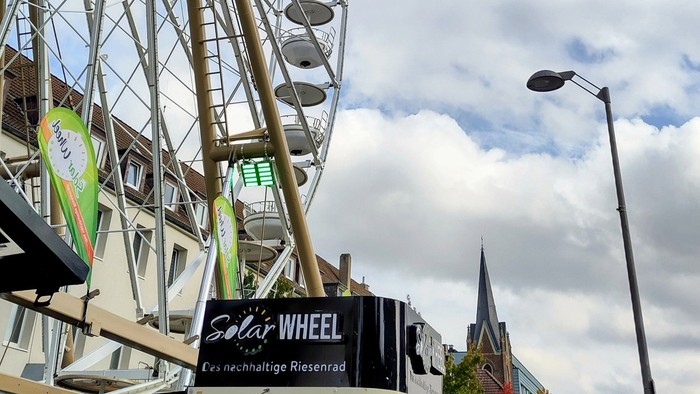 Ein Riesenrad im Vordergrund mit der Martinskirche im Hintergrund