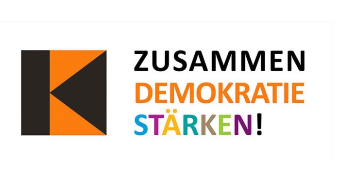 Logo zur Förderung der Stärkung der Demokratie mit farbigem Text „ZUSAMMEN DEMOKRATIE STÄRKEN!“ und stilisiertem Buchstaben „K“.