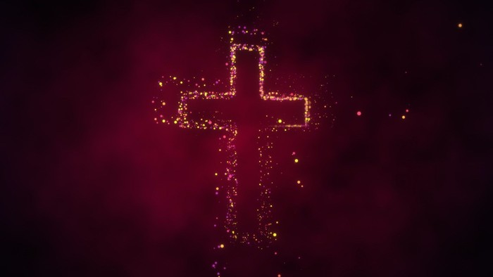 A glowing red cross with sparkling lights against a dark background.