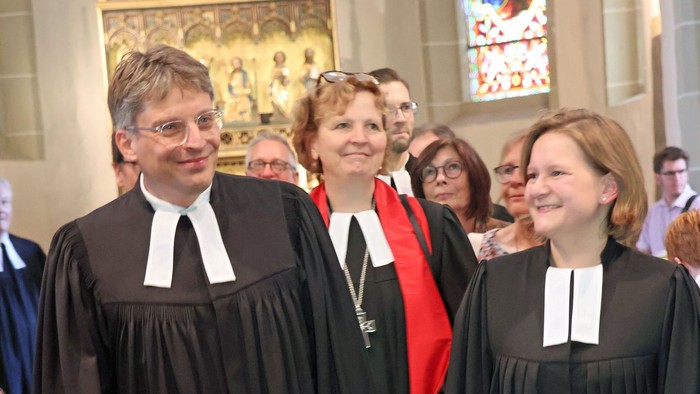 Geistliche in formellen Roben, die während einer Zeremonie in einer Kirche gehen.