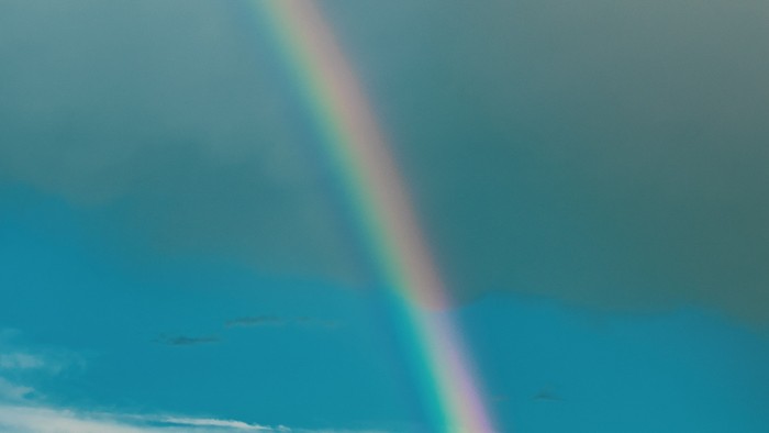 Ein Regenbogen spannt sich über den Himmel mit Wolken