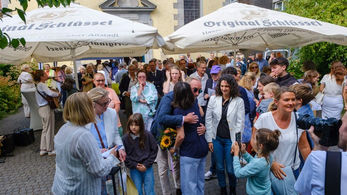 Kirchhof der Neanderkirche mit vielen Menschen und Schirme von der Hausbrauerei Zum Schlüssel