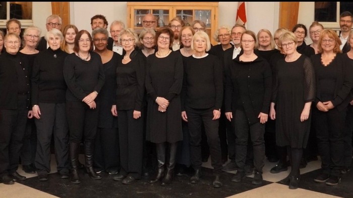 foto af et stort, blandet kor med sort tøj på