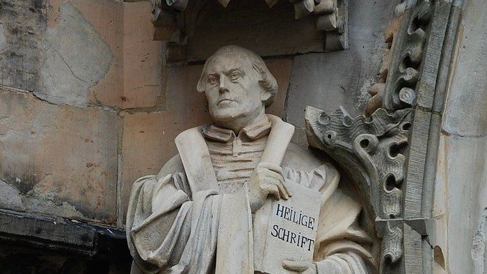 Steinfigur eines Mannes mit Buch, eingraviert