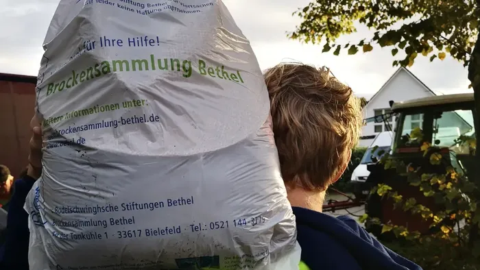 Jugendmitarbeiter trägt Sack zur Bethel- Kleidersammlung