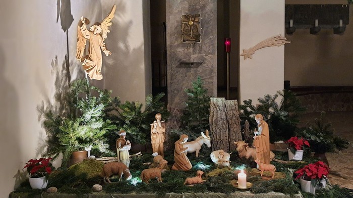 Eine Weihnachtskrippe mit Figuren und Deko in einem Raum