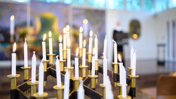 En kirke med mange lysestake på en kandlelygte i forgrunden