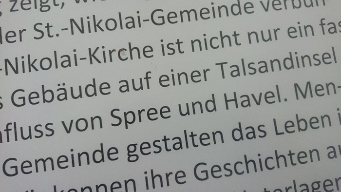 Eine Nahaufnahme von deutschem Text, der die St.-Nikolai-Kirche und ihre Gemeinde auf der Talsandinsel beschreibt.
