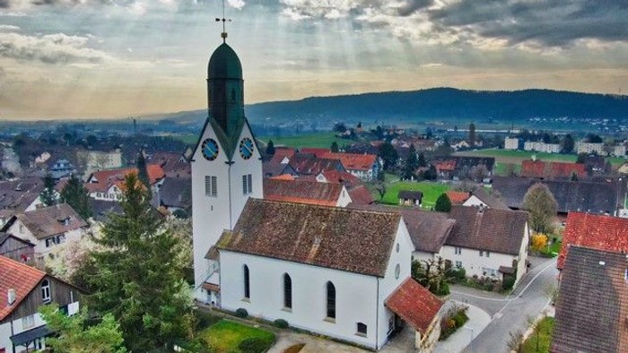 Kirchliche Dorfansicht bei bewölktem Himmel