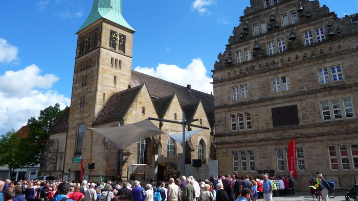 Große Menschenmenge vor historischem Gebäude mit hohem Turm und vielen Fenstern.