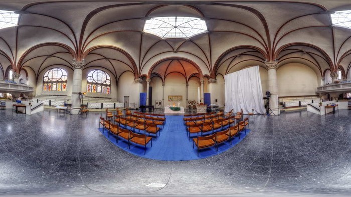 Großzügige Kirche mit hohen Gewölben und Holzbänken