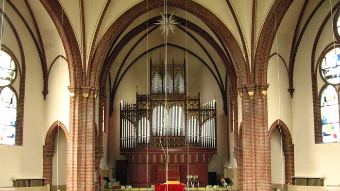 Innenraum einer Kirche mit hohem Gewölbe und Orgel