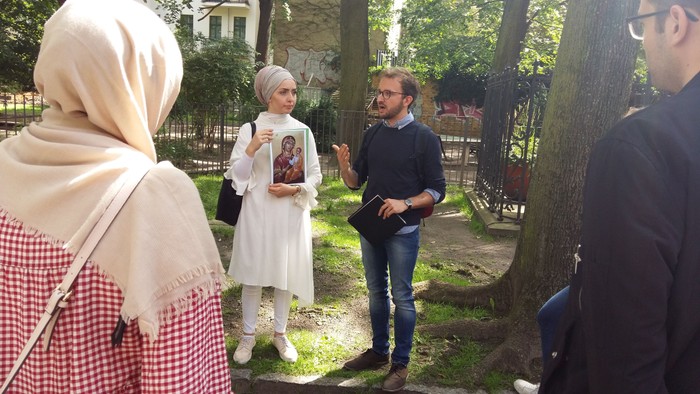Eine Gruppe von Menschen steht im Park und unterhält sich.