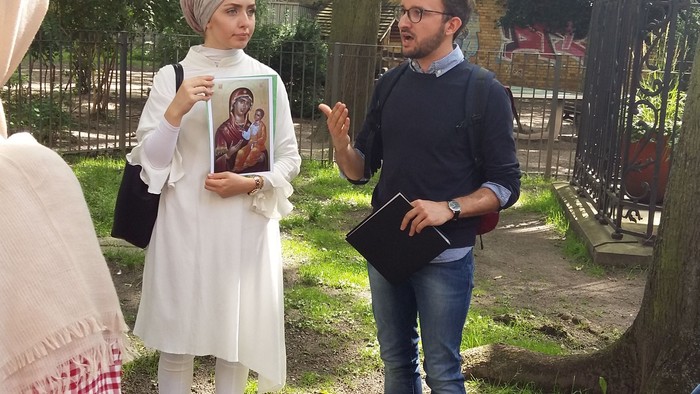Eine Gruppe von Menschen steht im Park und unterhält sich.