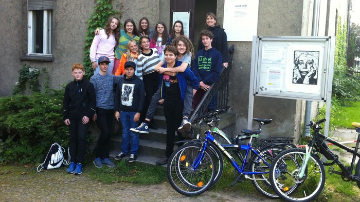 Eine Gruppe von Jugendlichen posiert vor einem Haus mit Fahrrädern