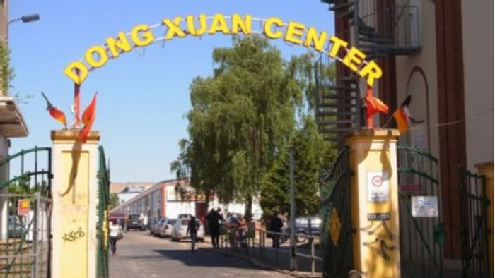 Bunte Marktszene im Dong-Xuan-Center mit verschiedenen Waren, Schuhen, Blumen und Souvenirs auf dem Display.
