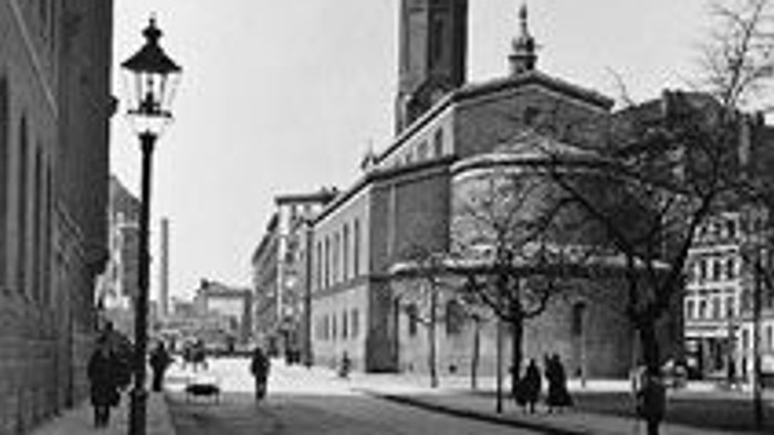 Historische Stadtstraße mit Kirche und Fußgängern