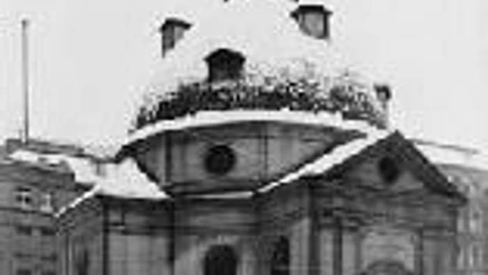Das Bild zeigt eine große Kirche mit Kuppel und Turm im Schnee.