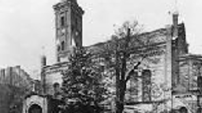 Altes Kirchengebäude an einer Kopfsteinpflasterstraße