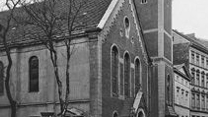 Altes Kirchengebäude mit hohem Turm an der Straße