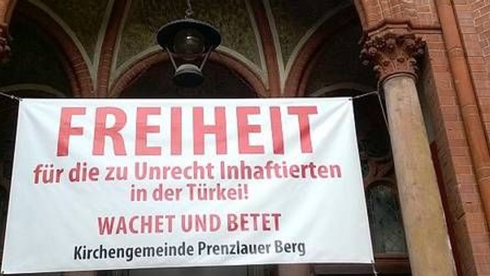 Gemeindebanner für Flüchtlinge an Kirchenportal