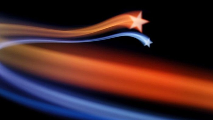 Ein farbenfrohes, verschwommenes Bild mit roten und blauen Lichtstreifen und einem Stern am Ende