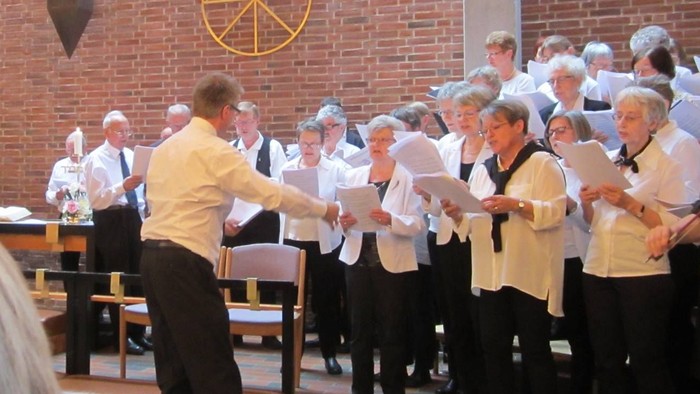 En kor sang i kirke med lys og mursten.