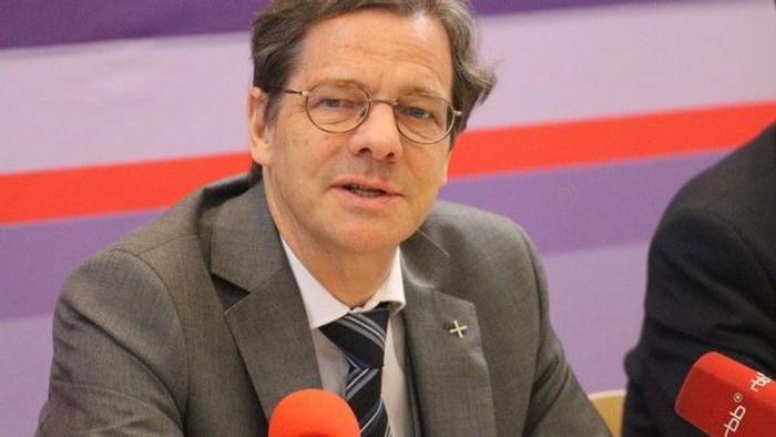 Mann im Anzug spricht in Mikrofon