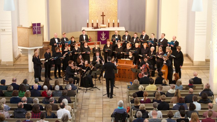 Ein Orchester spielt in einer Kirche vor einem Publikum