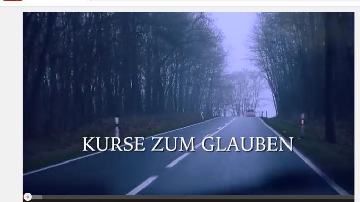 Das Bild zeigt eine kurvige Straße durch einen bewölkten Wald mit dem Text