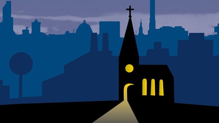 Eine Kirche steht vor einer Stadt bei Nacht