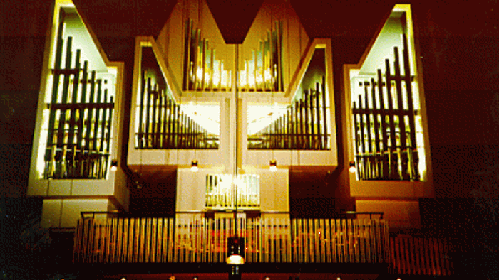 Große beleuchtete Pfeifenorgel mit mehreren Pfeifenreihen und schlankem, modernem Design.