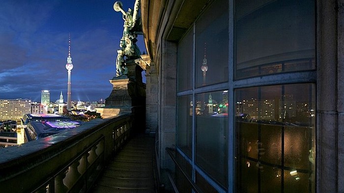 Abendliche Stadtansicht mit Fernsehturm und Statue