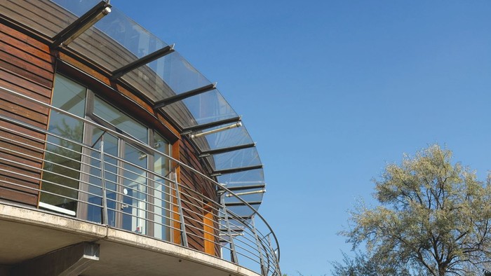 Moderne Glasfassade eines Gebäudes unter blauem Himmel