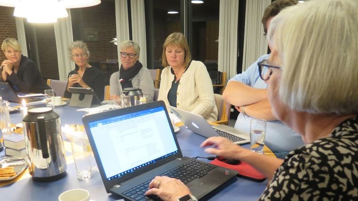 En gruppe kvinder sidder ved et bord med laptoper og drikkevarer.